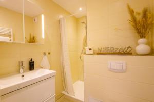 ein Badezimmer mit einer Dusche, einem Waschbecken und einer Badewanne in der Unterkunft CBlue: Küstenzauber barrierefrei mit Balkon in Heiligenhafen