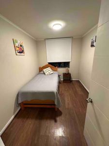 a bedroom with a bed in a room with wooden floors at Departamento amoblado por dias o meses in Calama