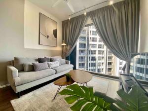 a living room with a couch and a large window at Stylish Nordic Suite, Pool View, 500mbps, GEO Bukit Rimau, Kota Kemuning in Shah Alam