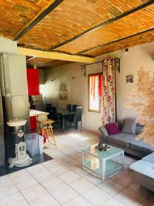 ein Wohnzimmer mit einem Sofa und einem Tisch in der Unterkunft Appartement au calme au milieu du vignoble de Gigondas in Gigondas