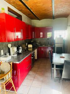 una cocina con armarios rojos y una mesa con sillas. en Appartement au calme au milieu du vignoble de Gigondas, en Gigondas