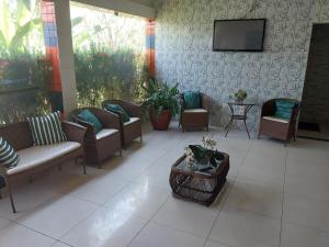 a lobby with chairs and a tv on a wall at Chesmar Plaza Hotel in Vera Cruz de Itaparica