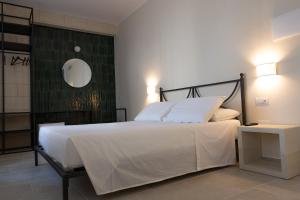 ein Schlafzimmer mit einem großen weißen Bett und einem Spiegel in der Unterkunft Oronti Accommodations in Lecce