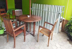 un tavolo con due sedie e un tavolo e sedie in legno di Wisma Almadina Syariah a Jepara