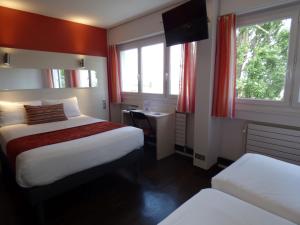 a hotel room with two beds and two windows at Cit'Hotel Escatel in Mâcon