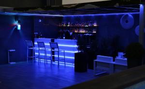 a blue bar with stools and a counter with drinks at LHP Napoli Palace & SPA in Naples