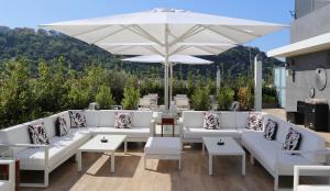 a patio with white couches and an umbrella at LHP Napoli Palace & SPA in Naples