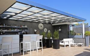 a patio with white chairs and a bar at LHP Napoli Palace & SPA in Naples