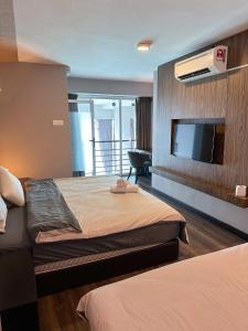 Cette chambre comprend 2 lits et une télévision à écran plat. dans l'établissement Maritime Suite by AirRise, à Jelutong