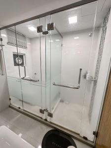 La salle de bains est pourvue d'une douche en verre et de toilettes. dans l'établissement Maritime Suite by AirRise, à Jelutong
