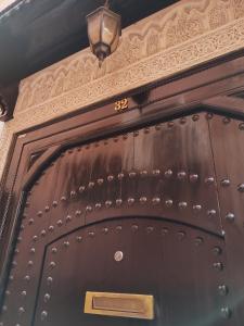 an old wooden door with a number on it at Riad L'Arganier in Marrakech