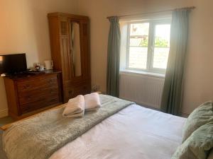 sypialnia z łóżkiem, komodą i oknem w obiekcie Alby horseshoes inn w mieście Erpingham