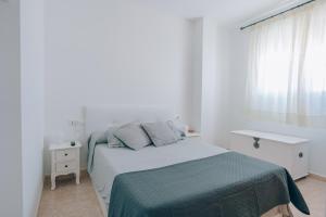 a white bedroom with a bed and a window at Vivienda Turística Sunbeach-Xilxes VT-42192-CS in Xilxes