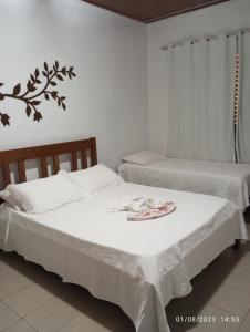 two beds in a room with a plate on top of it at Pousada Longe Vista in Tibagi
