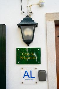 un panneau sur le côté d'un bâtiment avec un feu de rue dans l'établissement Casa do Briamante 9, à Sintra