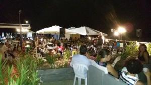 a crowd of people sitting in chairs at a concert at La Baia Di Ulisse in Venetico