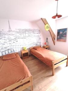 a bedroom with two beds and a drawing of the eiffel tower at Le tie-break in Pont-Croix