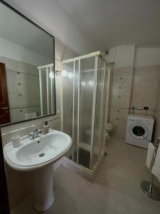 Un baño con lavabo, ducha e inodoro. en Valentino Bed And Breakfast, en Capodrise
