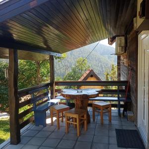 a patio with a table and chairs and a view at Ljubov kutak in Mokra Gora