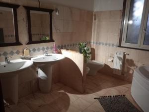 a bathroom with two sinks and a toilet at Milo's House in Mascalucia