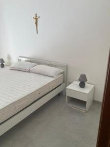 a bedroom with a bed and a cross on the wall at IL RICCIO appartamento sul mare in Torre Melissa