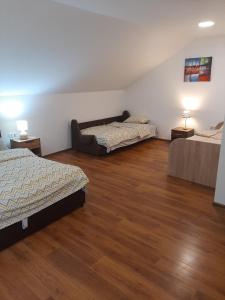 1 dormitorio con 2 camas y suelo de madera en Apartman Dan & Noc en Višegrad