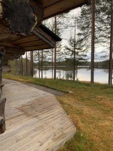 une terrasse en bois avec vue sur le lac dans l'établissement Villa Kuiske, à Kuusamo