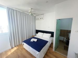 1 dormitorio con 1 cama y ventilador de techo en The Symphony of the Breeze, en Netanya