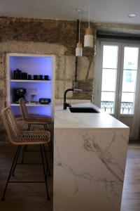 cocina con encimera blanca y 2 sillas en Apartamentos FOROPLAZA, en Lugo