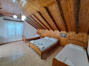 Habitación con 2 camas y techo de madera. en Guest House Argjiro Castle, en Gjirokastra