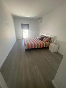 a bedroom with a bed and a wooden floor at Apartamento amplo e moderno - perto do estádio futebol in Tondela