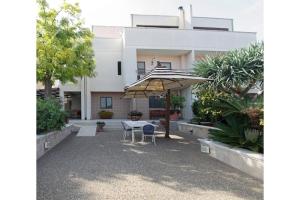a patio with a table and an umbrella in front of a building at B&B Villa Maria Pia in Monopoli