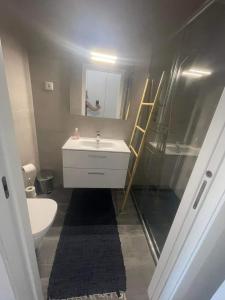 a bathroom with a sink and a shower and a mirror at Apartamento amplo e moderno - perto do estádio futebol in Tondela