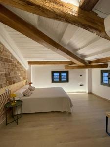 a bedroom with a bed and a brick wall at ROS CENTRIC Cal Ros in Montblanc