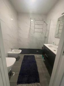 a bathroom with a toilet and a sink at Apartamento amplo e moderno - perto do estádio futebol in Tondela