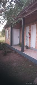 ein Backsteinhaus mit zwei weißen Garagentüren in der Unterkunft Pousada Longe Vista in Tibagi
