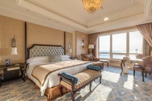 a bedroom with a large bed and a large window at The Castle Hotel, a Luxury Collection Hotel, Dalian in Dalian