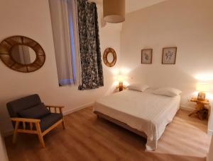 Un dormitorio con una cama, una silla y un espejo. en Le Marty 1, en Carcassonne