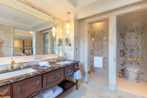 La salle de bains est pourvue de 2 lavabos et d'un grand miroir. dans l'établissement The Castle Hotel, a Luxury Collection Hotel, Dalian, à Dalian