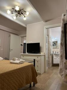 a bedroom with a bed and a flat screen tv at Martinahouse in Vico nel Lazio