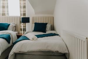 a bedroom with two beds with blue and white at Alice - spacious 3 bedroom house contractor accommodation in Sunderland