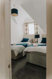 a bedroom with two beds and a window at Alice - spacious 3 bedroom house contractor accommodation in Sunderland