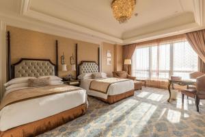 duża sypialnia z 2 łóżkami i biurkiem w obiekcie The Castle Hotel, a Luxury Collection Hotel, Dalian w mieście Dalian