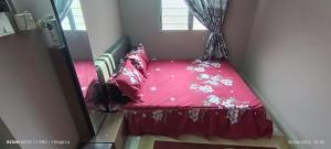 ein kleines rotes Bett in einem Zimmer mit Fenster in der Unterkunft Homestay Rezeki Batu Gajah in Batu Gajah
