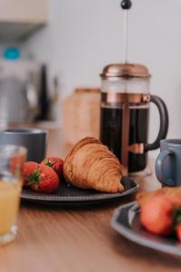 a plate with a croissant and strawberries on a table at Alice - spacious 3 bedroom house contractor accommodation in Sunderland