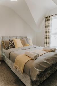 a large bed with pillows on it in a bedroom at Alice - spacious 3 bedroom house contractor accommodation in Sunderland