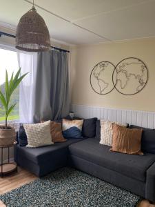 a living room with a couch and two maps on the wall at Bay view chalet, 28 Sea Valley in Bucks Mills