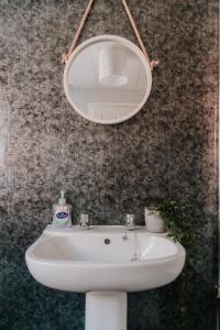 lavabo blanco con espejo en la pared en Alice - spacious 3 bedroom house contractor accommodation, en Sunderland
