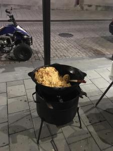 a chicken cooking in a pot on a street at Old House Gyumri in Gyumri