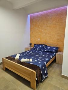 a bedroom with a bed with blue sheets and blue pillows at Booking Apartments Alone 2 in Zemun